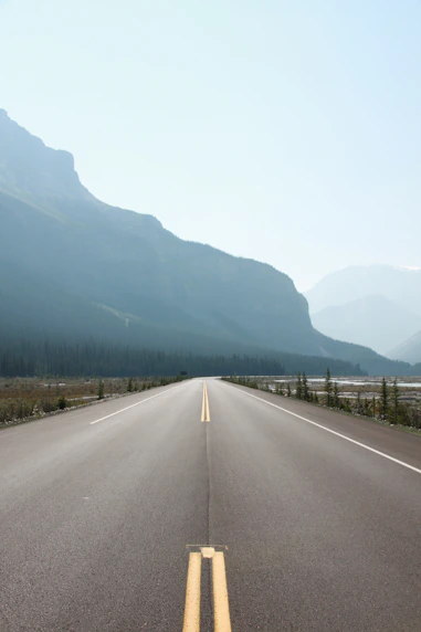 A wide highway stretching through a mountainous landscape.