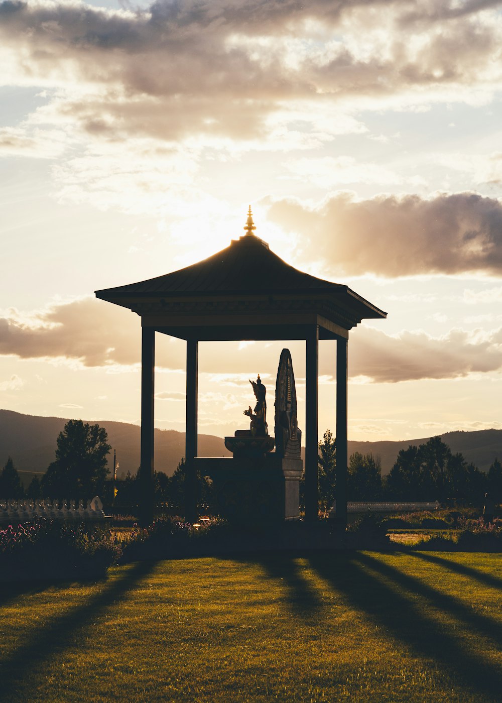 gazebo preto no campo de grama verde sob o céu nublado durante o dia