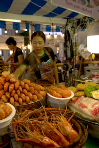 A diverse group of women registering at a vibrant expo booth filled with seafood displays.
