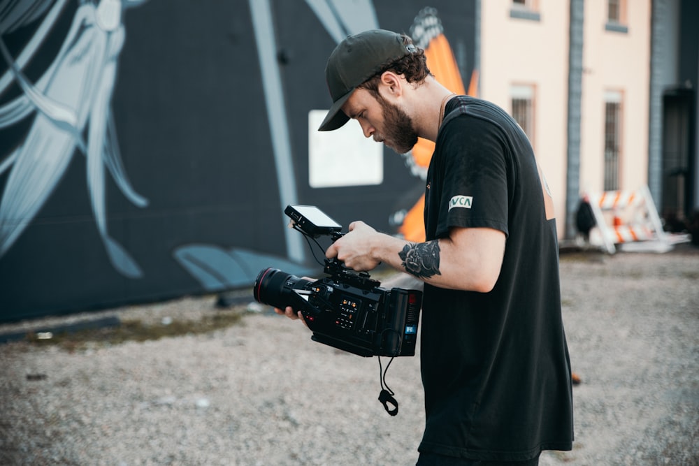 Un uomo che tiene una macchina fotografica di fronte a un edificio