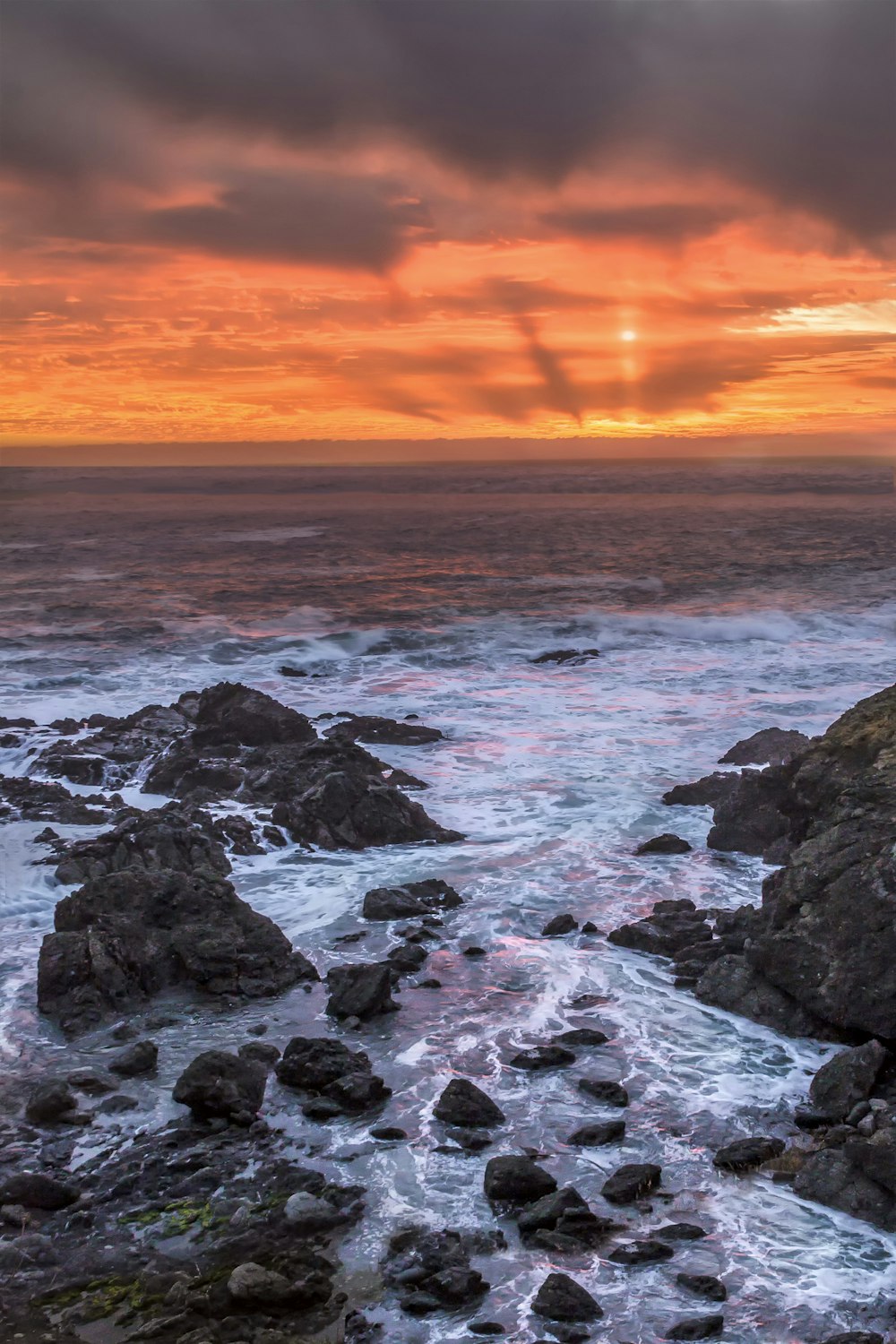 rocky shore during sunset with ocean waves