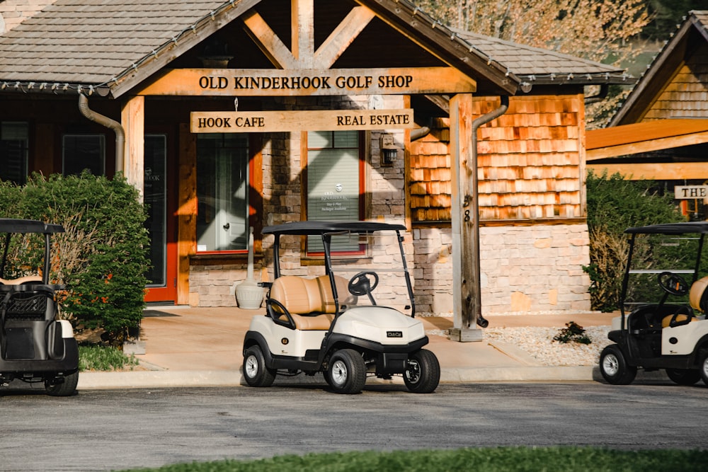 Weißer und schwarzer Golfwagen, der tagsüber in der Nähe eines braunen Betongebäudes geparkt ist