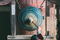 person holding round brown metal tool
