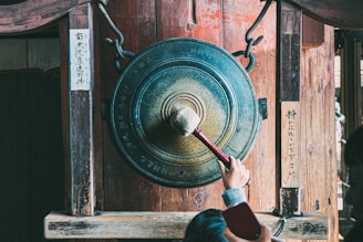 person holding round brown metal tool