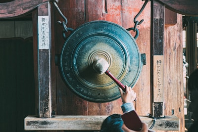 person holding round brown metal tool