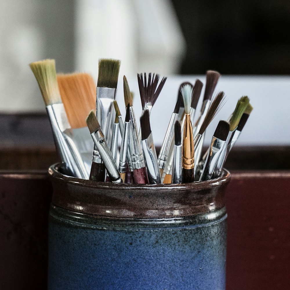 paint brushes in blue container