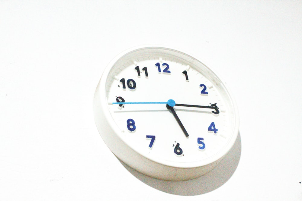 white and blue analog clock at 10 00