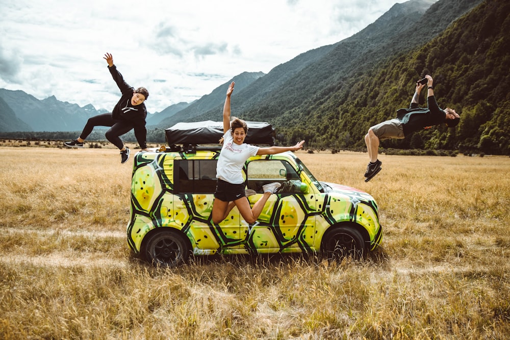 man in black t-shirt and black shorts standing beside green and black jeep wrangler