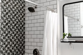 white shower curtain on stainless steel shower head