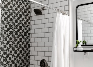 white shower curtain on stainless steel shower head