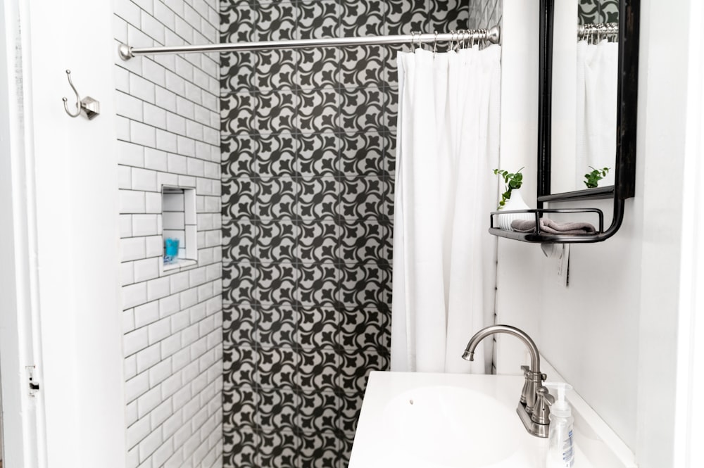 white ceramic sink beside white and gray floral shower curtain