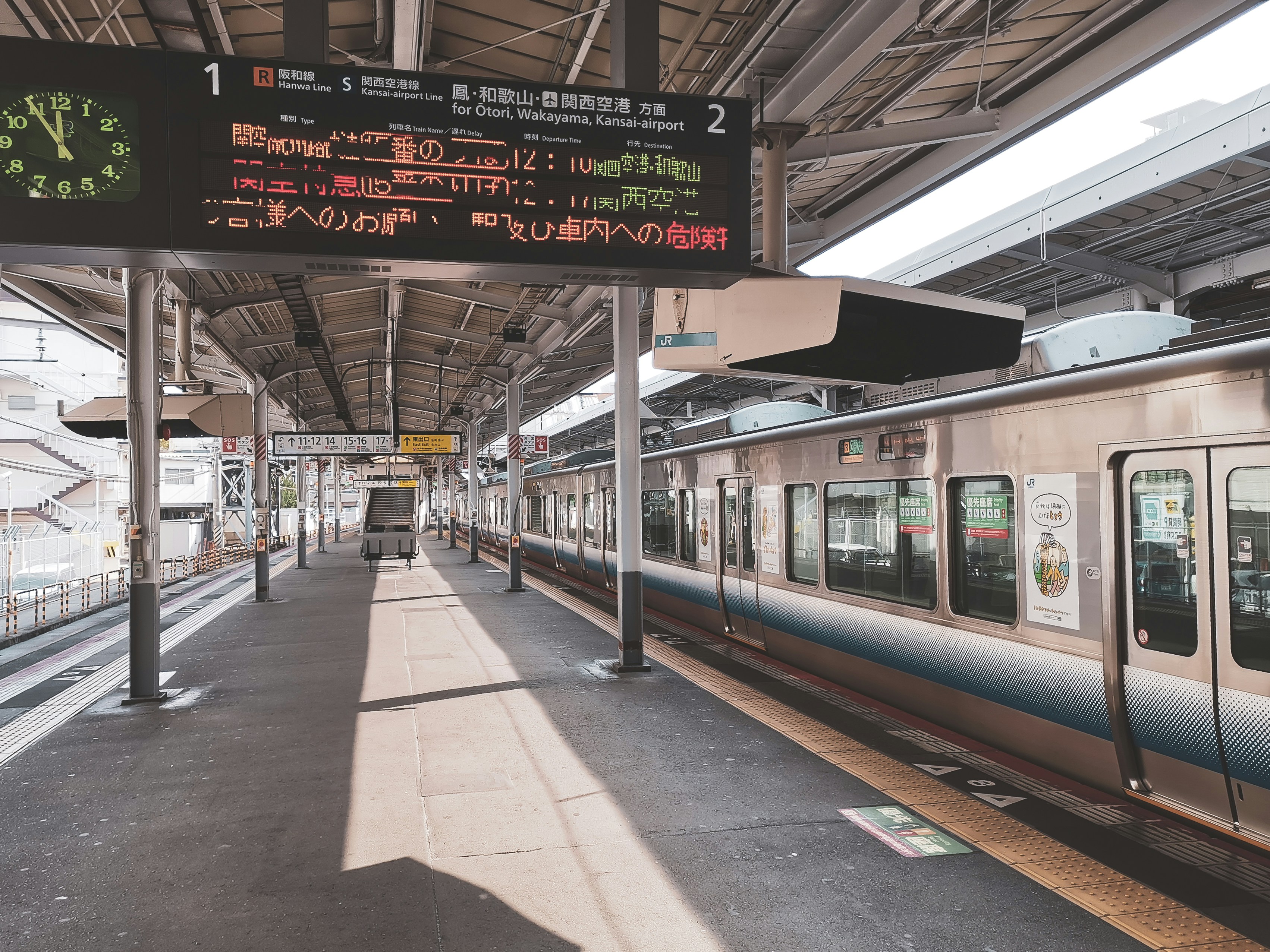 A crowded train platform in Japan with 'Service Suspended' signs, emphasizing transport disruption