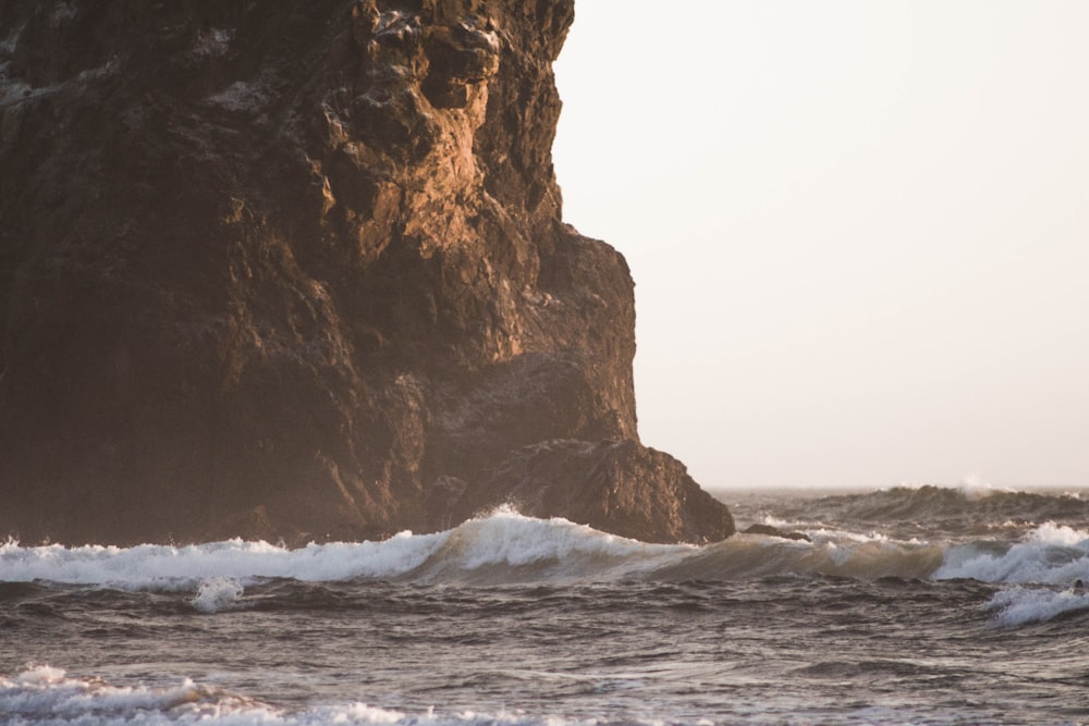 brown rock formation on sea during daytime