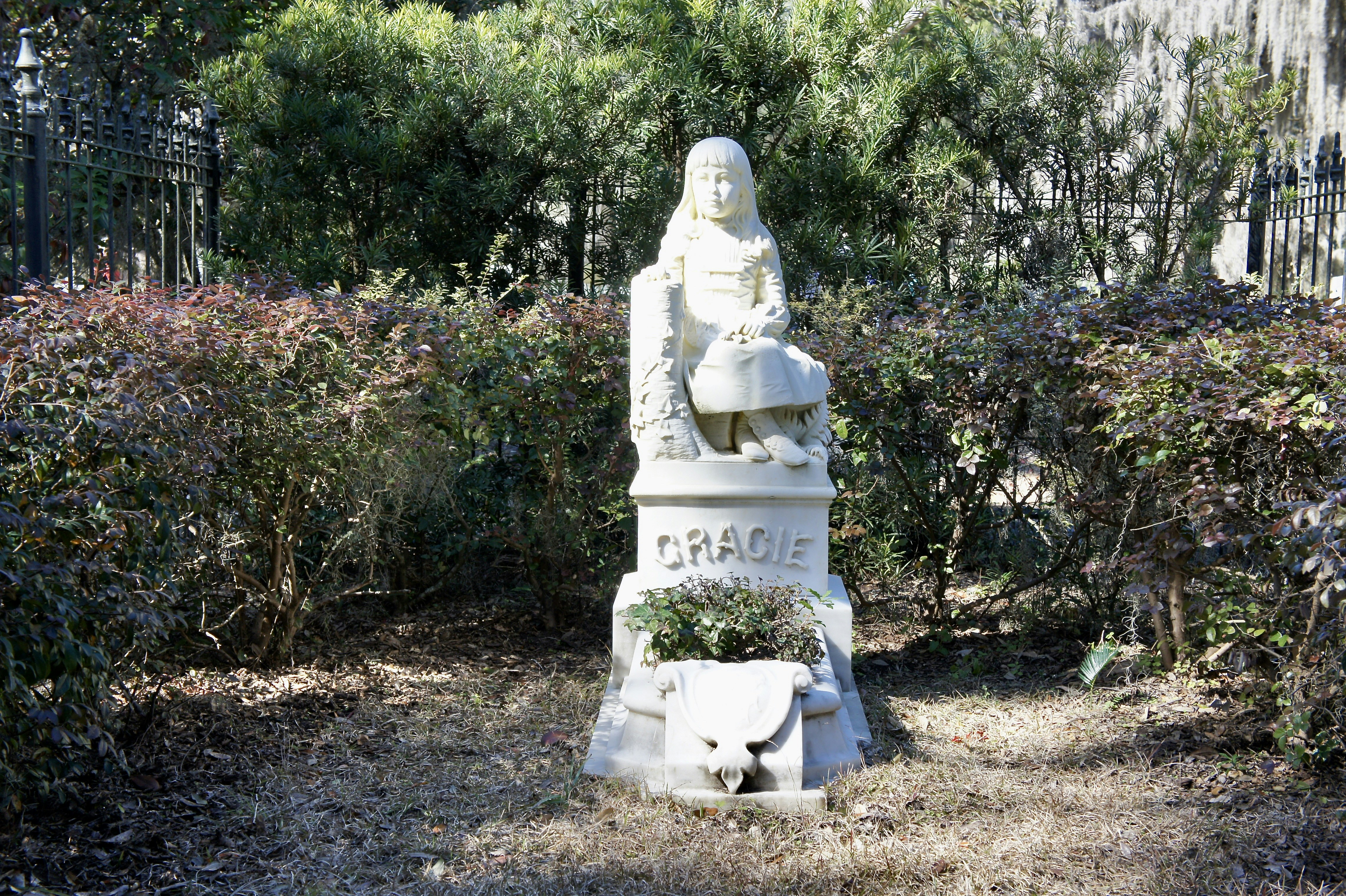 white statue of man sitting on white bench