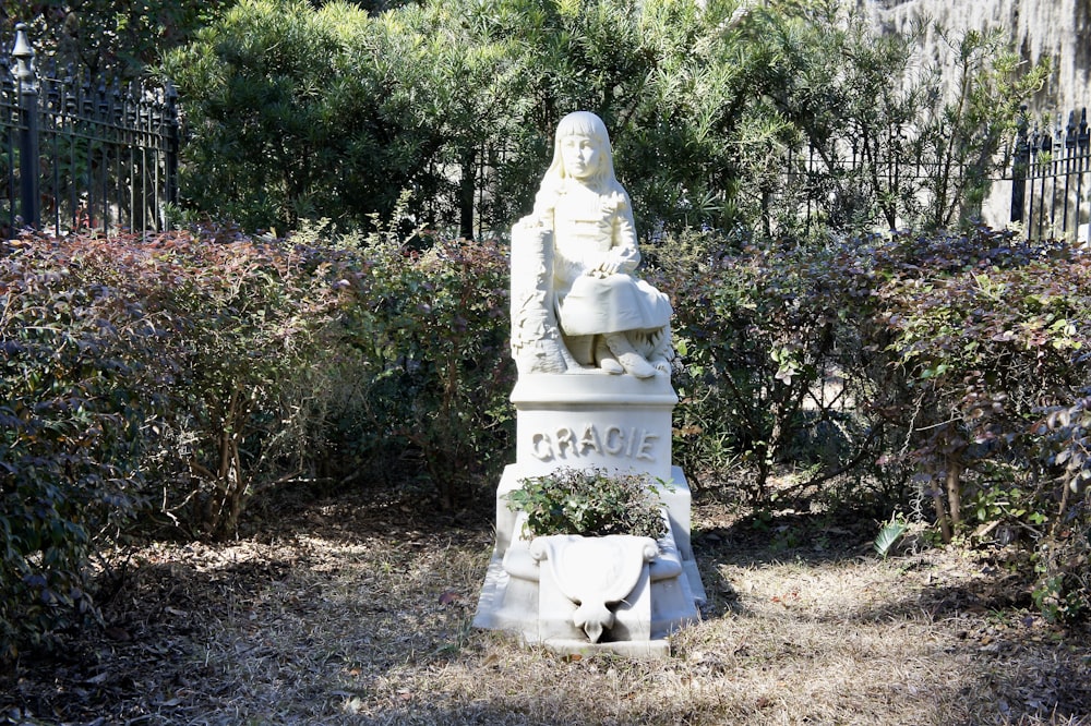 white statue of man sitting on white bench