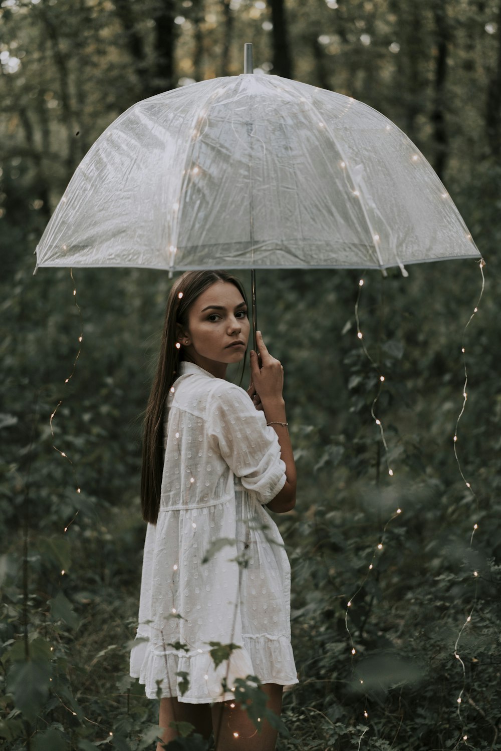 woman in white and gray floral long sleeve dress holding umbrella
