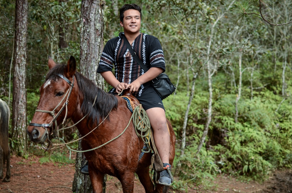 homme en chemise à manches longues rayée noire et blanche équitation cheval marron