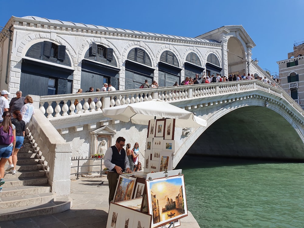 people standing on white concrete bridge during daytime