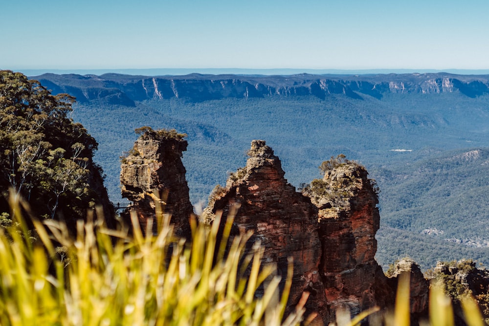 brown rock formation near green grass during daytime