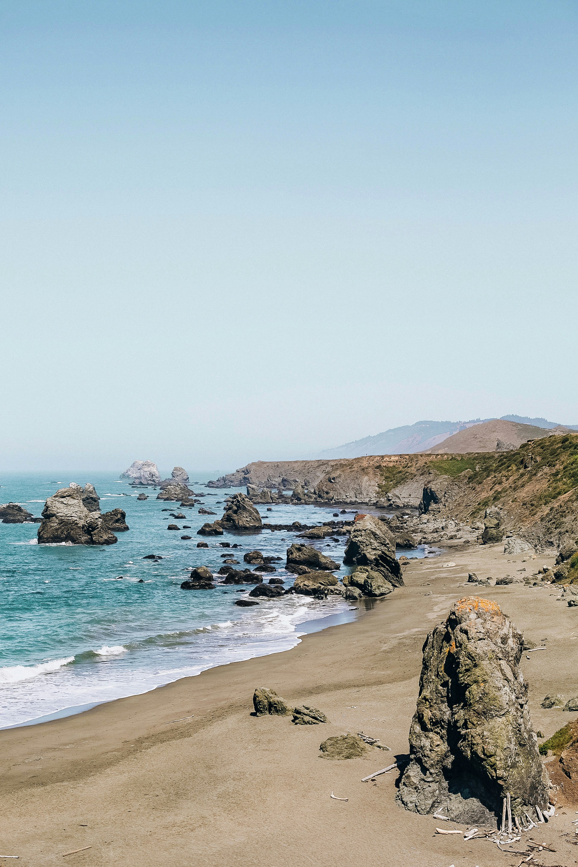brown rocky shore near body of water during daytime