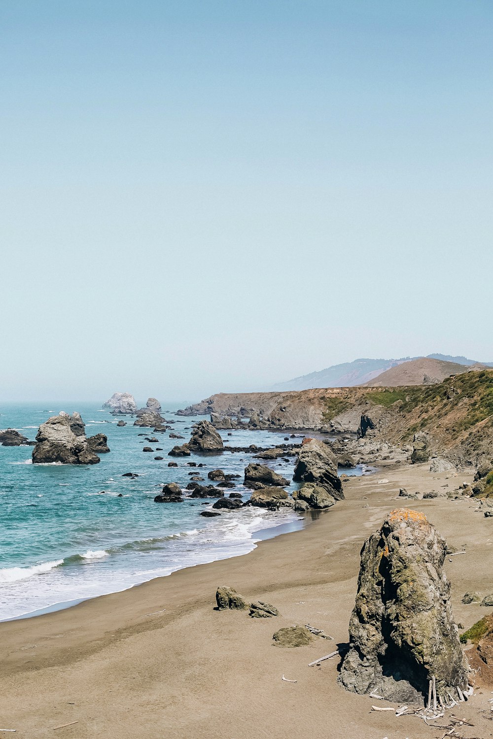 brown rocky shore near body of water during daytime