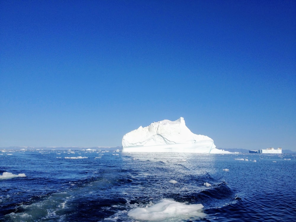 black rock formation on sea under blue sky during daytime