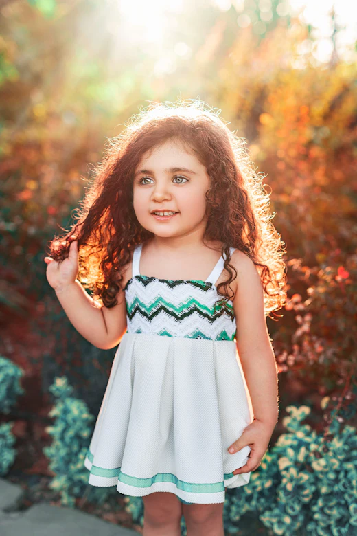 Menina de vestido ao pôr do sol