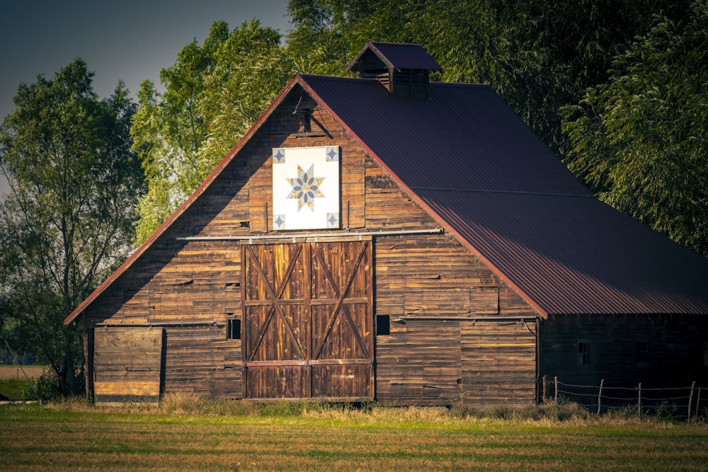 brown wooden barn on green grass field during daytime
