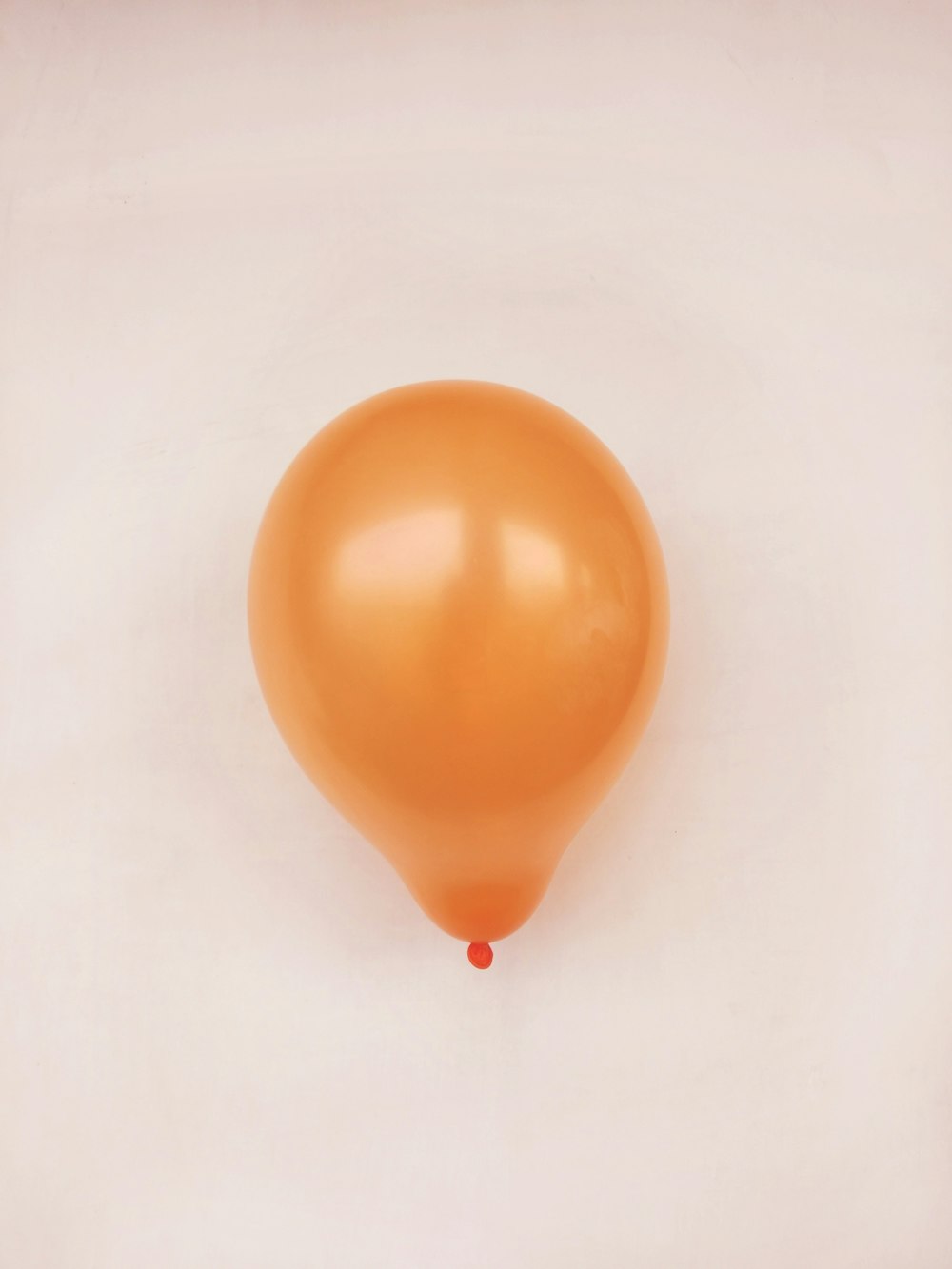 globo naranja sobre superficie blanca