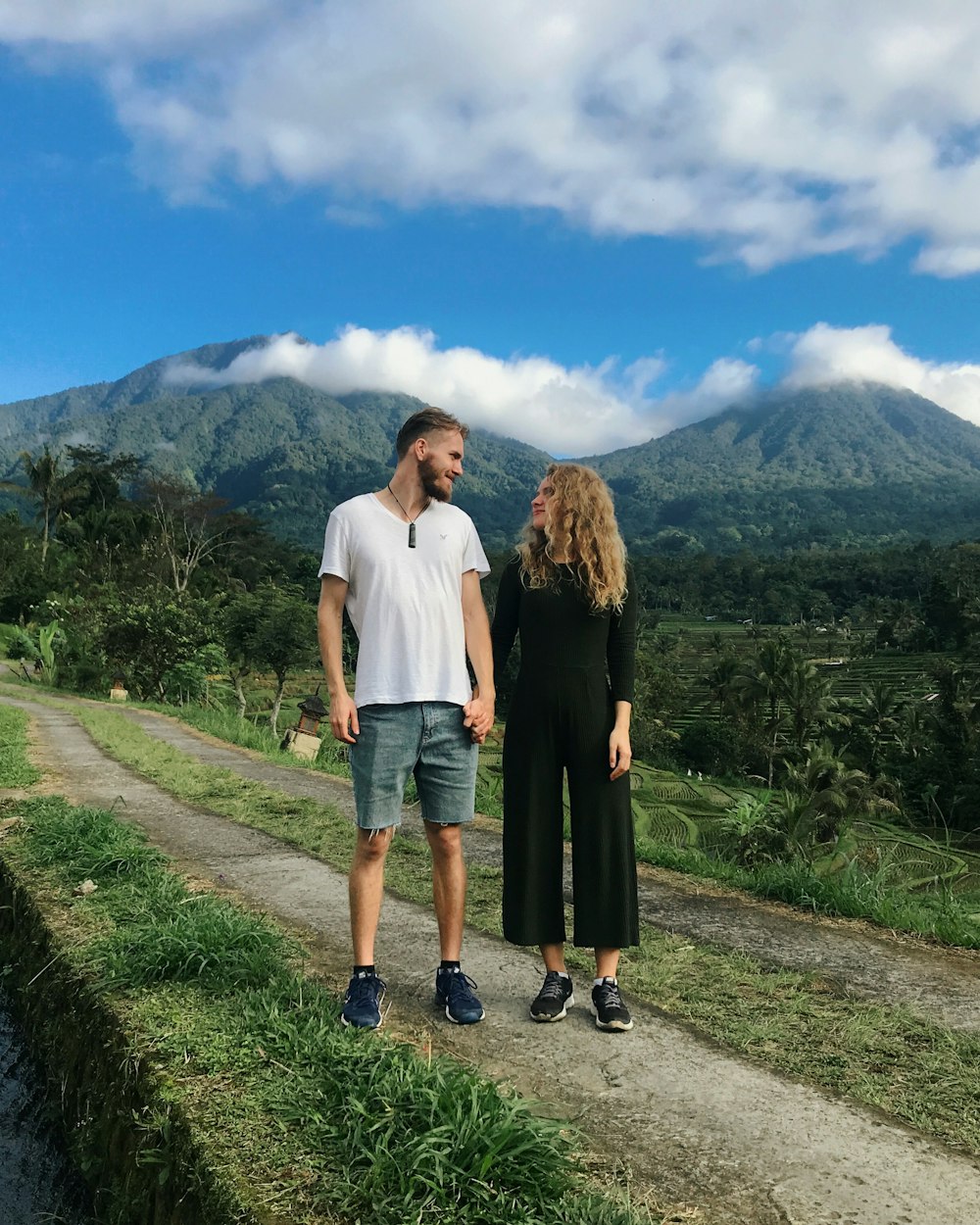 man and woman standing on green grass field during daytime