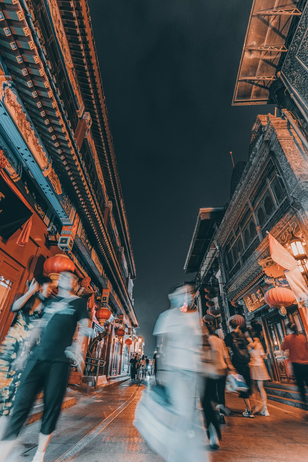 people walking on street near buildings during night time