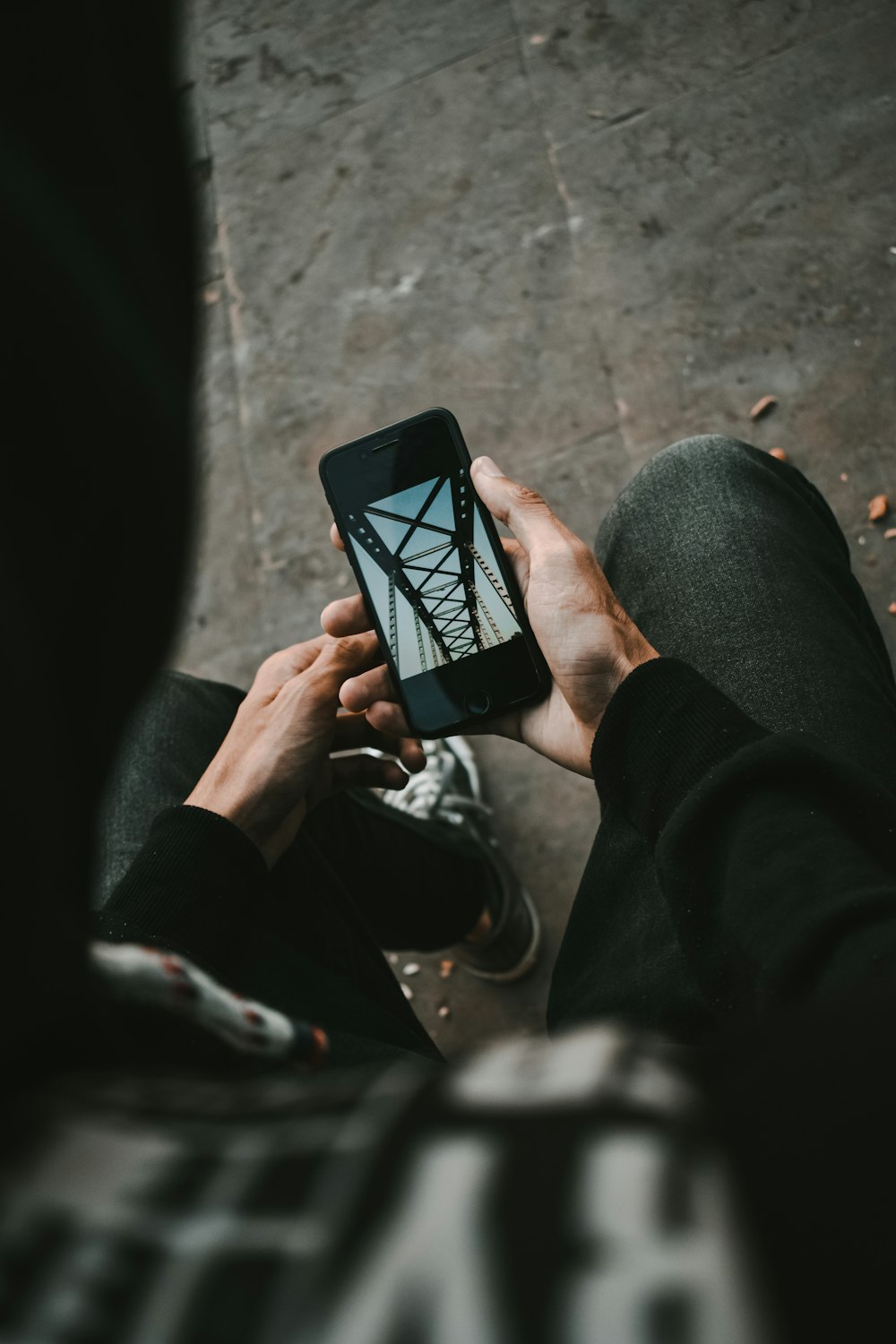 person holding black smartphone taking photo of gray concrete wall