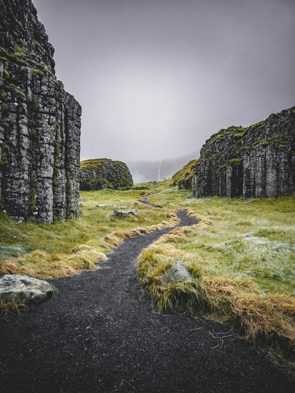 green grass field near gray rock formation during daytime