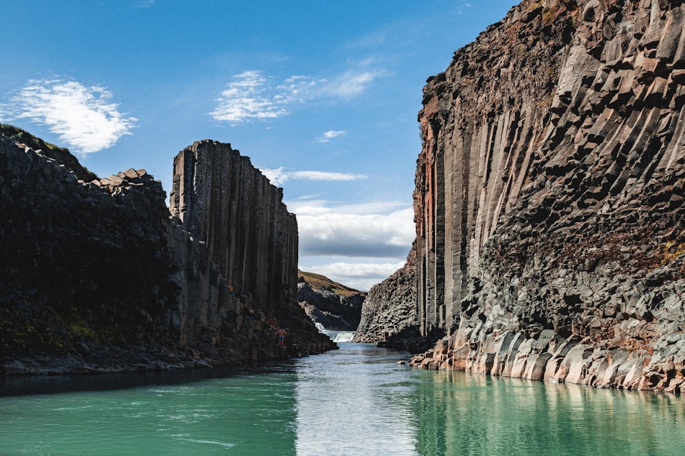 brown rocky mountain beside body of water during daytime