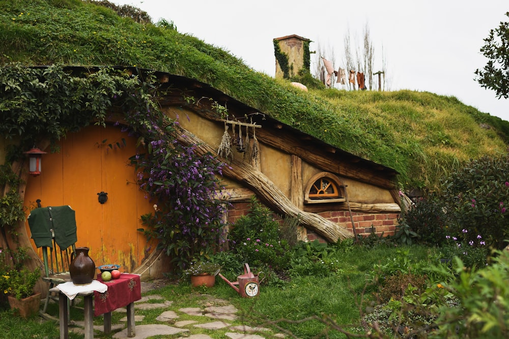 昼間は緑の芝生のそばに茶色い木造住宅