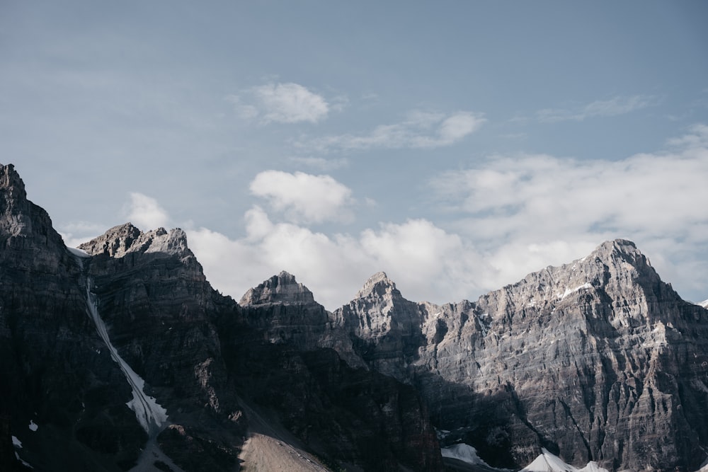 brown rocky mountain under white clouds during daytime