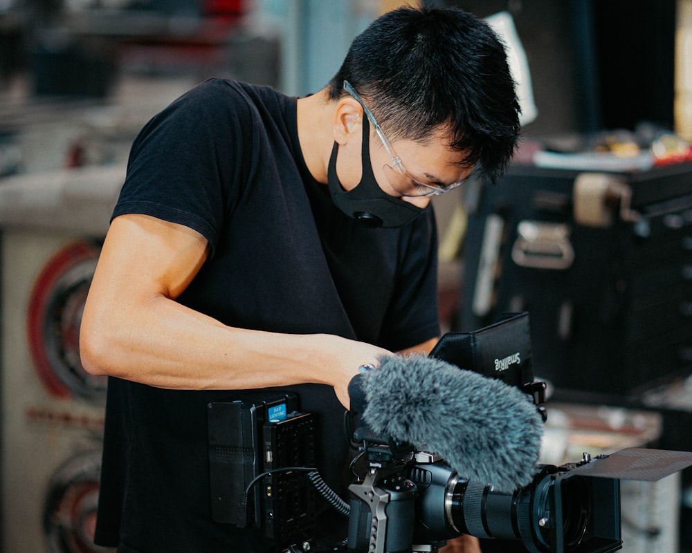 man in black crew neck t-shirt holding black video camera