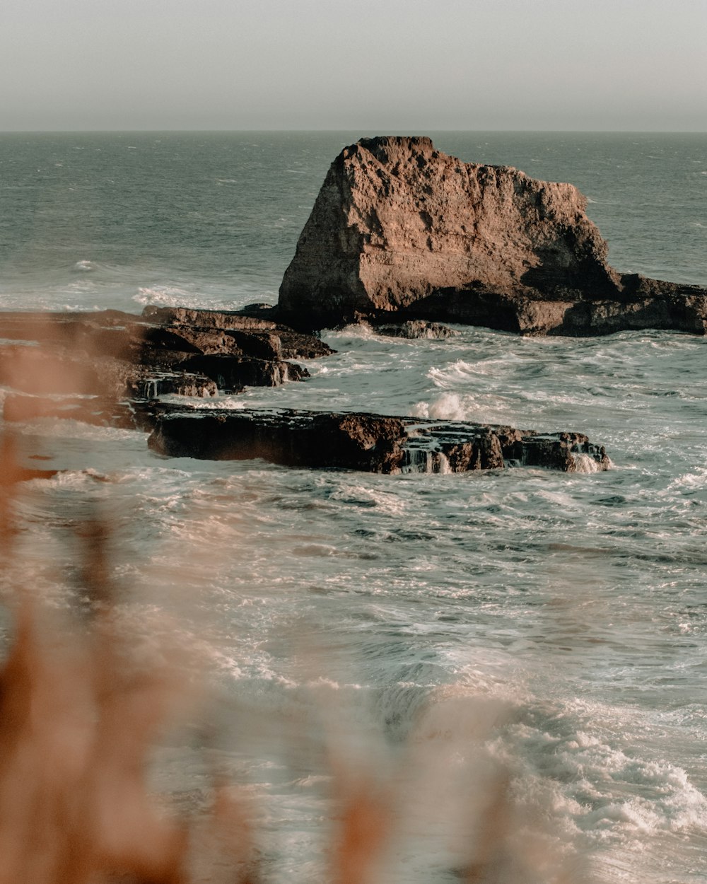 brown rock formation on sea water during daytime