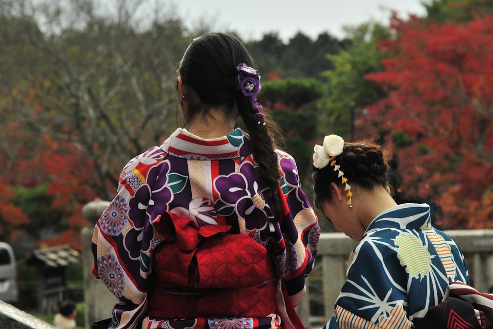 woman in red and blue floral dress standing near woman in red and white floral dress