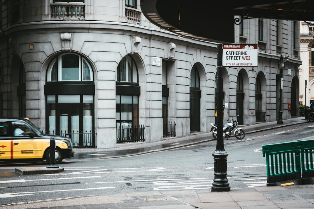 yellow taxi cab on road near building during daytime