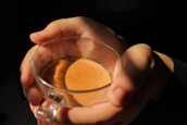 Close-up of hands holding a warm cup of tea during a therapy session.