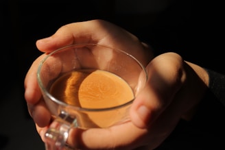 Close-up of hands gently holding a comforting cup of tea.