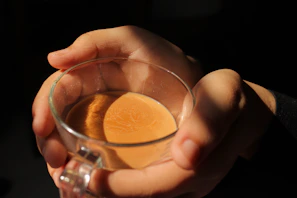 Warm scene of a hand holding a cup of coffee with visible vapor, inviting to a moment of inner connection.