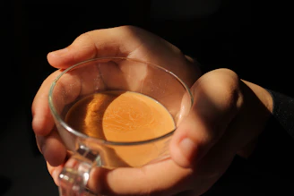 Close-up of hands holding a calming herbal tea cup, steam gently rising.