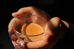 Close-up of hands gently holding a cup of tea, symbolizing warmth and connection.