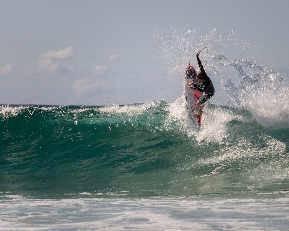 man surfing on sea waves during daytime