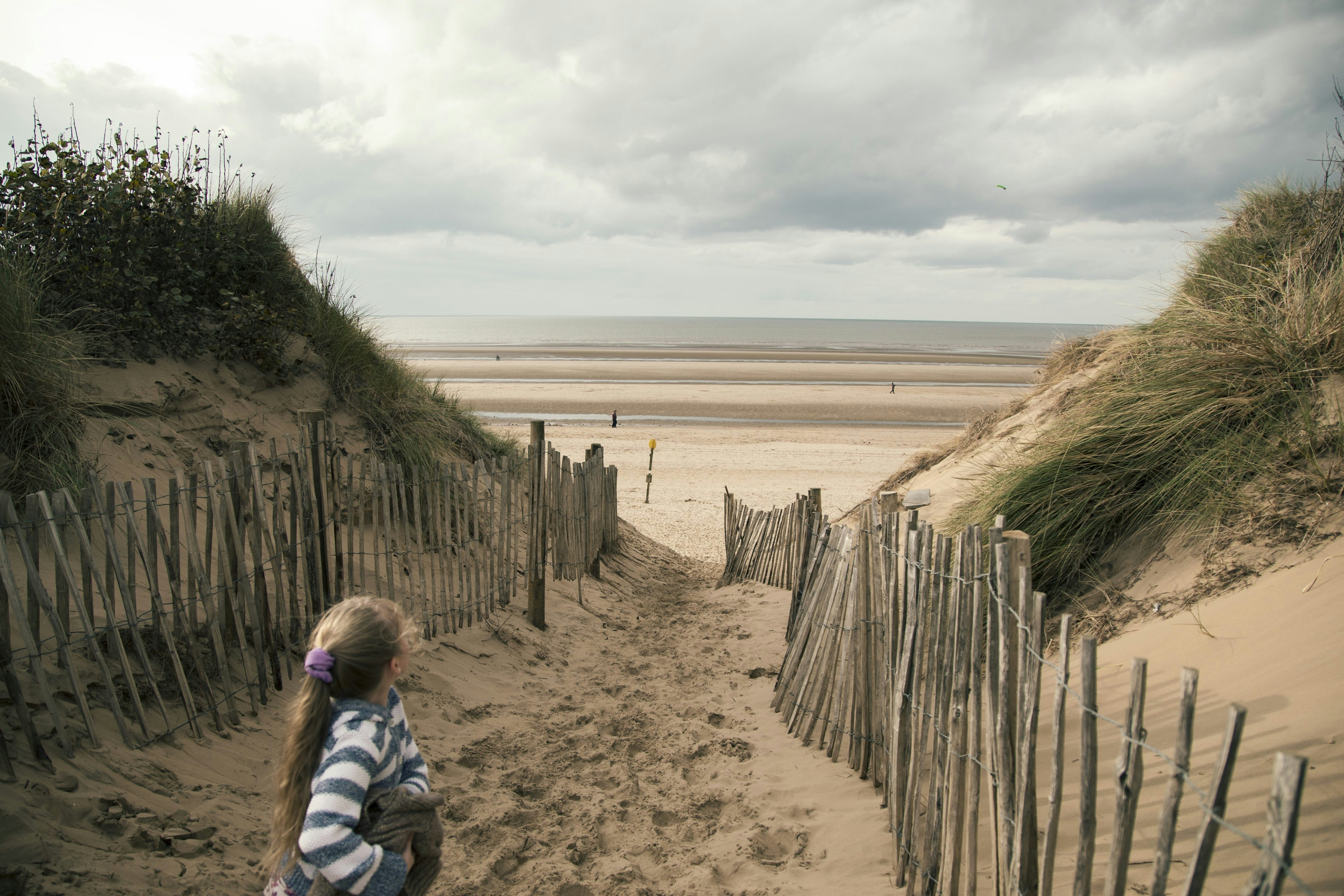 A child going to the beach on a cold, windy day