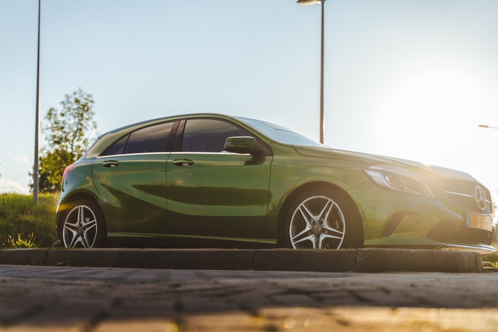 green sedan on gray asphalt road during daytime