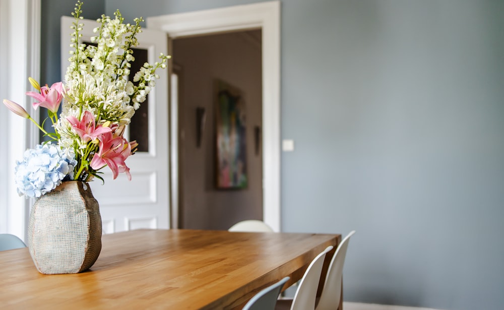 white and pink flower bouquet on brown wooden table