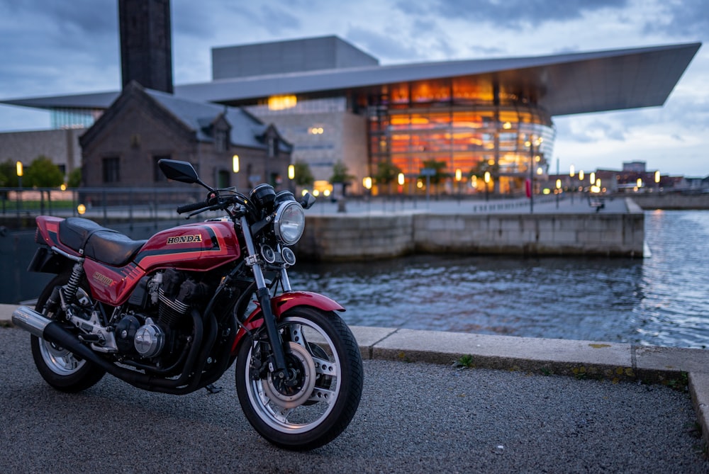 black and red naked motorcycle parked on gray concrete road during daytime